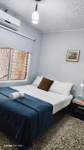Habitación pequeña con cama y ventana en Hotel Loft Dorado, en Floridablanca