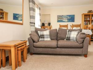 a living room with a couch and a table at Jubilee Cottage in Penzance