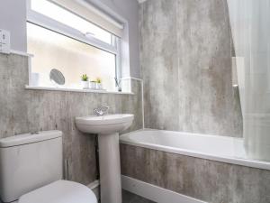a bathroom with a toilet and a sink and a bath tub at Jubilee Cottage in Penzance +26 photos