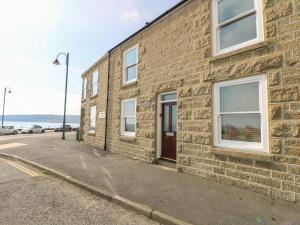 um edifício de tijolos com uma porta ao lado em Jubilee Cottage em Penzance