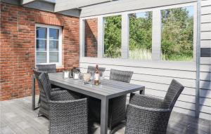 Une table et des chaises en bois sont disponibles sur la terrasse. dans l'établissement Gorgeous Home In Dagebll With Wifi, à Dagebüll
