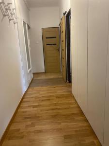 a hallway with a wooden floor and a door at Apartament przy Parku Czartoryskich II in Puławy