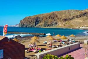een strand met parasols en mensen op het zand bij Summer Breeze Tenerife, Palm-Mar in Palm-mar