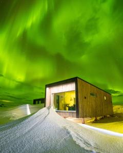 a building under the aurora in the snow at Varanger View in Vardø