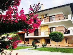 a large building with pink flowers in front of it at Guesthouse Alkioni in Lithótopos