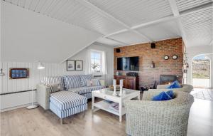 a living room with couches and a brick wall at Pet Friendly Home In Hvide Sande With House A Panoramic View in Havrvig