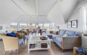 a living room with blue and white furniture and a table at Pet Friendly Home In Hvide Sande With House A Panoramic View in Havrvig