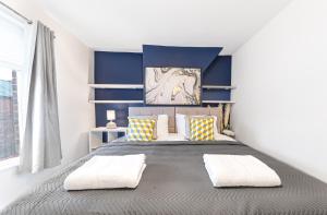 een slaapkamer met een groot bed met blauwe muren bij *King Bed* Comfy City House in Barrow in Furness