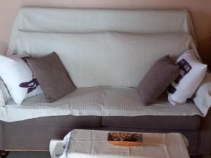 a white couch with pillows and a tray on it at Elm Tree Dream Catcher in StrinÃ½las