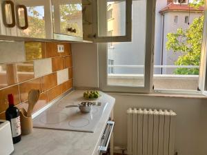 a kitchen with a white stove top oven next to a window at Orfey Apartment in Sofia