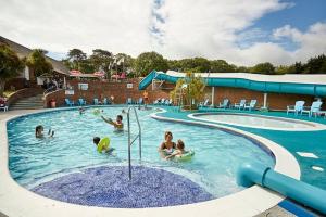 un groupe de personnes jouant dans une piscine dans l'établissement "Malton" LG27 Pet Friendly, à Shanklin