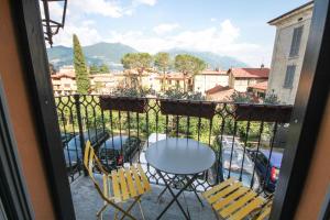 uma vista para uma varanda com uma mesa e cadeiras em Due Colonne em Menaggio