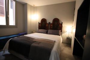 a bedroom with a large bed with a wooden headboard at Due Colonne in Menaggio