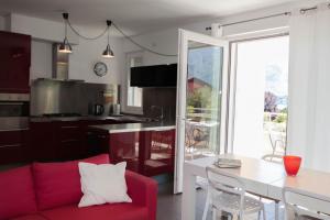 un soggiorno con divano rosso e tavolo di IsaBellaVista a Tremezzo