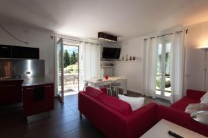 un soggiorno con divano rosso e tavolo di IsaBellaVista a Tremezzo