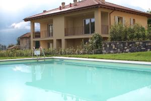 a villa with a swimming pool in front of a house at Via Volta Lenno in Tremezzo