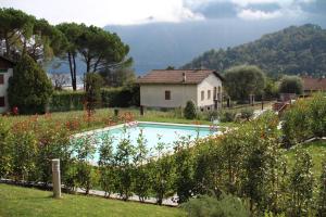 a swimming pool in a garden next to a house at Via Volta Lenno in Tremezzo
