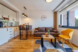 a kitchen and a living room with a couch and a table at Vardar 64 (Titova Vila) in Zlatibor