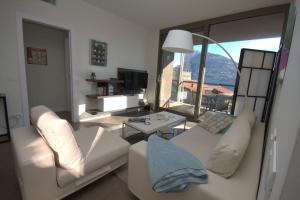 a living room with a white couch and a table at Vista Panorama Jewel - Acquaseria, San Siro by LoveComo in San Siro