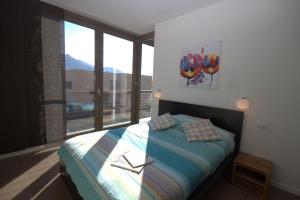 a bedroom with a bed and a large window at Vista Panorama Jewel - Acquaseria, San Siro by LoveComo in San Siro +22 photos