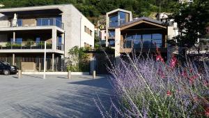 a parking lot in front of a building with purple flowers at Vista Panorama Jewel - Acquaseria, San Siro by LoveComo in San Siro
