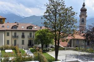 a building with a clock tower and a tree at Villa Castelli in Menaggio