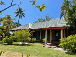 a house on the beach with palm trees at Turia's Beach Villa in Moorea