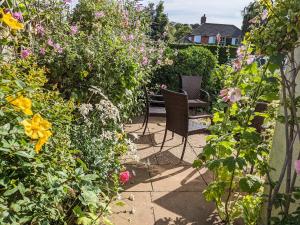 a garden with two chairs and flowers at Beach House in Sheringham