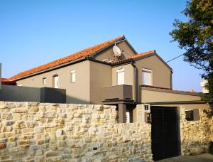 une maison derrière un mur en pierre avec un portail dans l'établissement Apartment"Tica"Zaton with pool, à Zaton