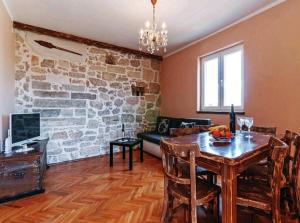 - un salon avec une table et un mur en pierre dans l'établissement Apartment"Tica"Zaton with pool, à Zaton