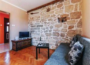 - un salon avec un canapé et un mur en pierre dans l'établissement Apartment"Tica"Zaton with pool, à Zaton