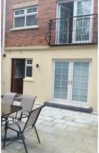 a patio with two chairs and a table in front of a building at St Elmos Townhouse in Derry Londonderry
