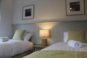 a bedroom with two beds and a lamp on a table at Bunratty west Townhouse in Bunratty