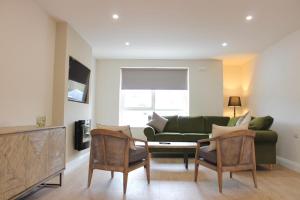 a living room with a green couch and chairs at Bunratty west Townhouse in Bunratty