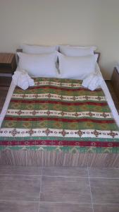 ein Bett mit einer Decke und Kissen darauf in der Unterkunft Zanger Hotel in Goris