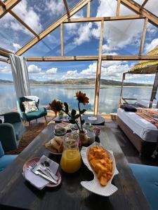 - une table avec nourriture et vue sur l'eau dans l'établissement Hotel - Titicaca Dora, à Puno