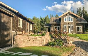 una casa con una valla de piedra delante de ella en Gorgeous Home In Nybergsund With Kitchen, en Nybergsund