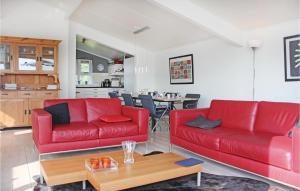 una sala de estar con 2 sofás rojos y una mesa. en 3 Bedroom Gorgeous Home In Workum, en Workum