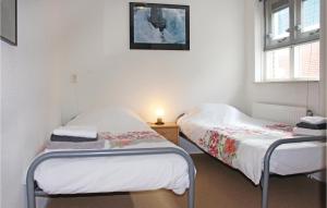 2 camas individuales en una habitación con ventana en 3 Bedroom Gorgeous Home In Workum, en Workum