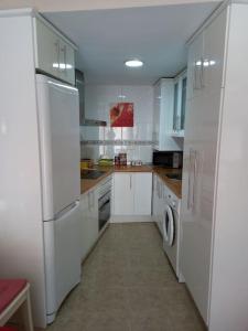 希耶薩的住宿－Apartamento tranquilo cerca de zonas verdes，厨房配有白色橱柜和白色冰箱。