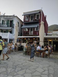 a group of people sitting at tables with umbrellas at Oniro PargaTown Luxury Suites in Parga