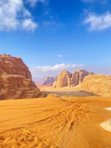 a desert scene with rocks and a blue sky at Authentic Wadi Rum camp & tours in Wadi Rum