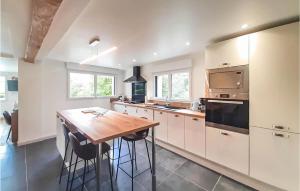 cocina con armarios blancos y mesa de madera en Lovely Home In Ledinghem With Kitchen en Seninghem