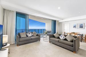 una sala de estar con 2 sofás y vistas al océano. en 49th Floor Apartment with Ocean and Skyline Views sitting above the Hilton Hotel, en Gold Coast