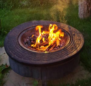 a fire pit with a tire on top of it at The Meadows Bell Tents in Clare