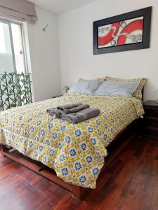 ein Bett mit einer gelben und blauen Bettdecke darauf in der Unterkunft Habitaciones en Miraflores - Departamento compartido Maka's Home in Lima