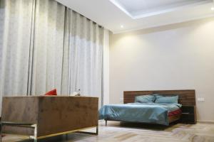 1 dormitorio con cama y ventana grande en Greedy Five Kigali, en Kigali