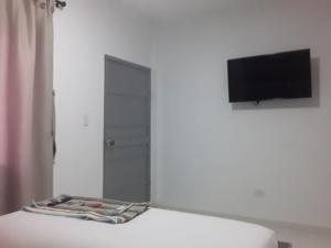 San Juan del CesarHOSTAL KASHI KAI的客房设有一张带镜子的床和一台电视