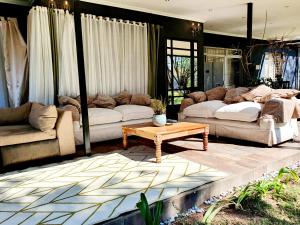 a living room with two couches and a coffee table at Dream Sandton Villa 'Maison de Ky' Swimming pool tennis court free WI-FI in Johannesburg