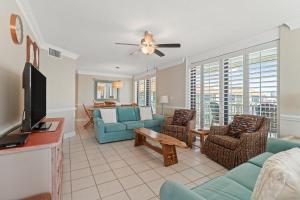 a living room with a couch and chairs and a tv at Summer House 1501B in Orange Beach